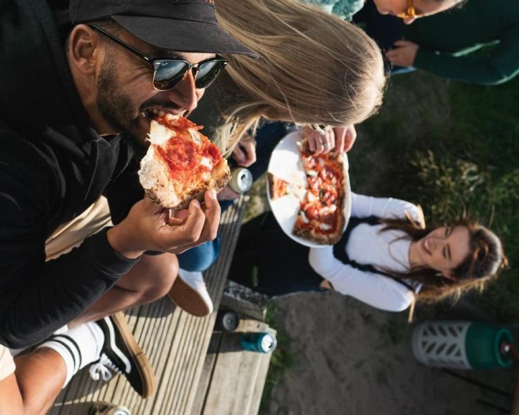 people eating pizza at a pizza making cookery class