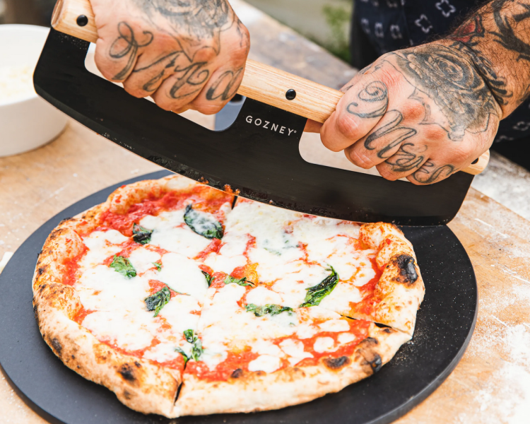 pizza being cut on a a pizza making experience