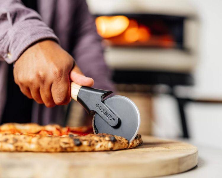 cutting a pizza on a pizza making class