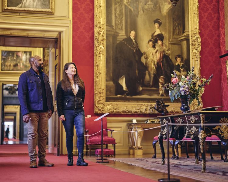 two people walking through the red room in blenheim palace