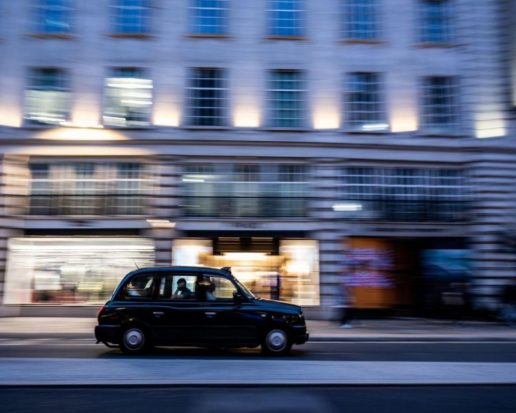 A black cab driving down a london street