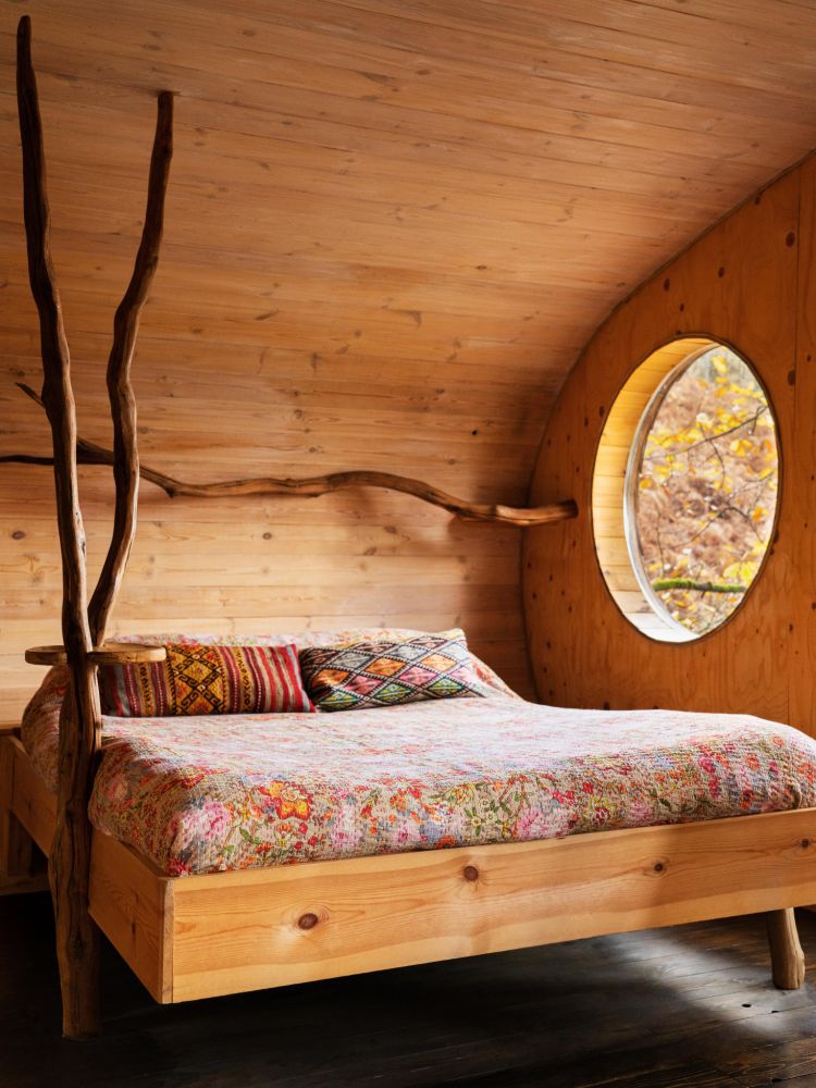 the bedroom with double bed inside a treehouse in the woods in wales