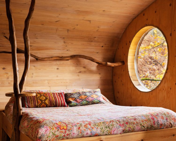 the bedroom with double bed inside a treehouse in the woods in wales