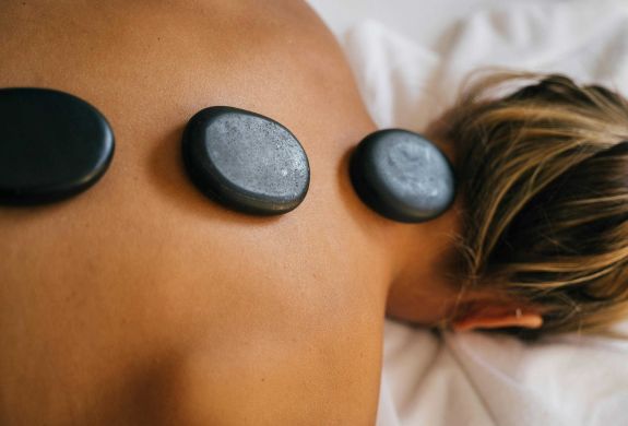 woman having a hot stone back massage treatment