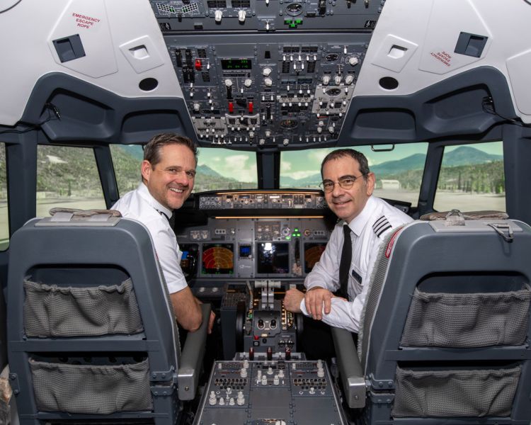 two men in the cockpit of a boeing 737 flight simulator at luton airport