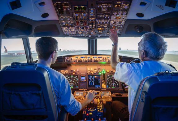 two men in the cockpit of a boeing 737 flight simulator at luton airport