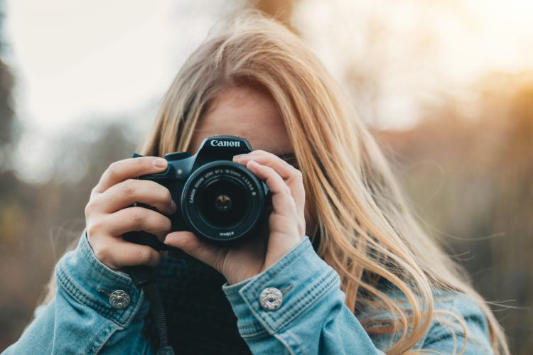 Woman taking a photo with a black camera on a photography workshop