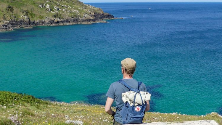 Man looking out over cornish coastline