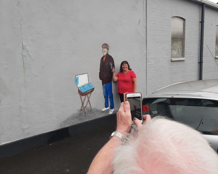 Woman having photo taken next to del boy mural on only fools and horses tour