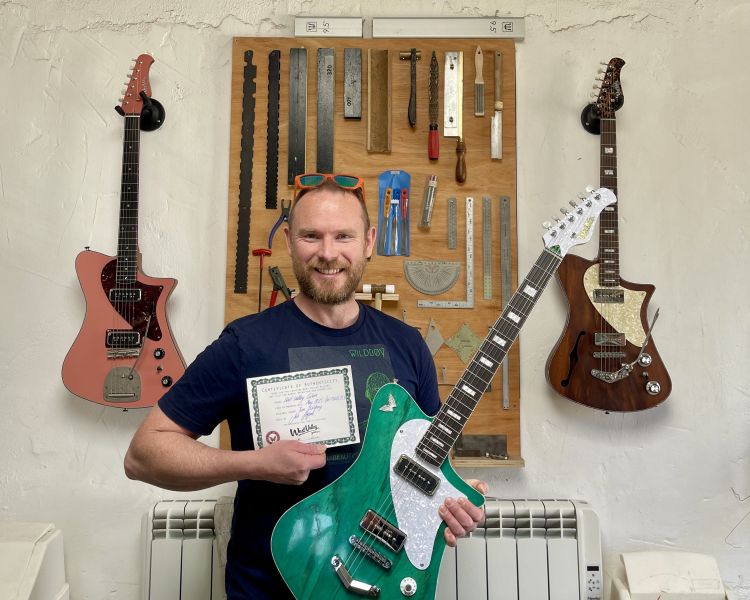Man holding green guitar