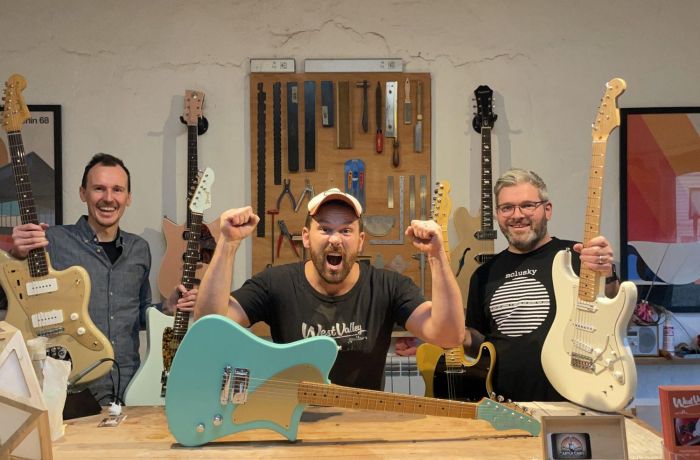 3 men holding guitars
