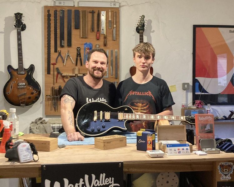 2 men holding a guitar