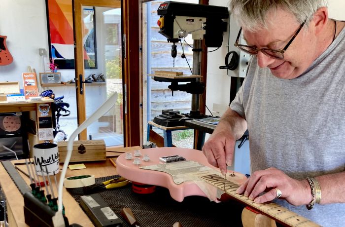 Man working on a guitar