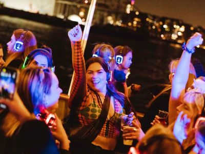 happy party goers on a silent sounds party river cruise on the thames in london