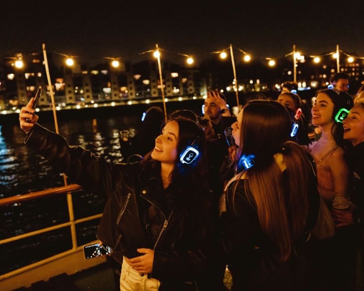 girl taking selfie on a silent sounds party river cruise on the thames in london