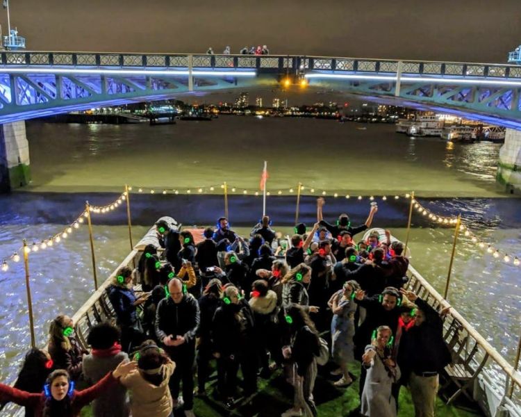 crowd at a silent sounds party on a river cruise on the thames in london