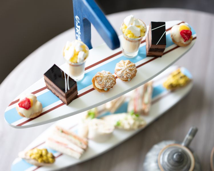 afternoon tea displayed on a surfboard display stand for an afternoon tea at a hotel and spa in hampshire