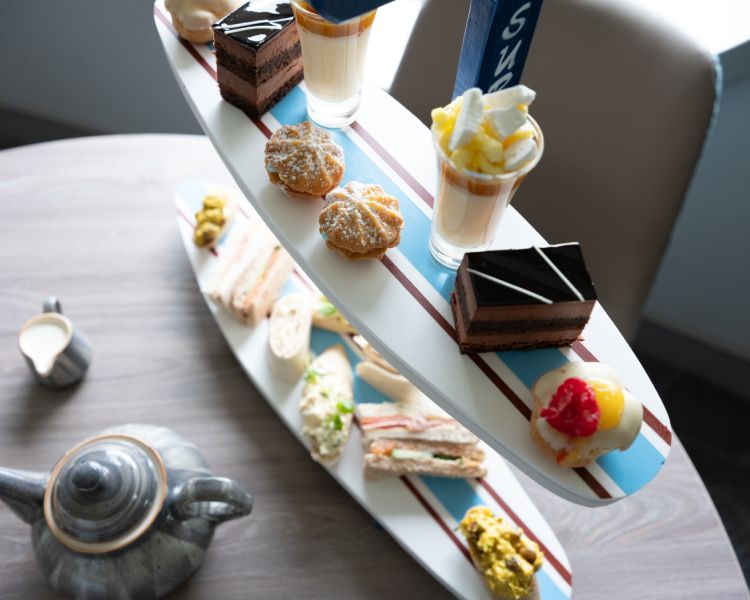 afternoon tea displayed on a surfboard display stand for an afternoon tea at a hotel and spa in hampshire