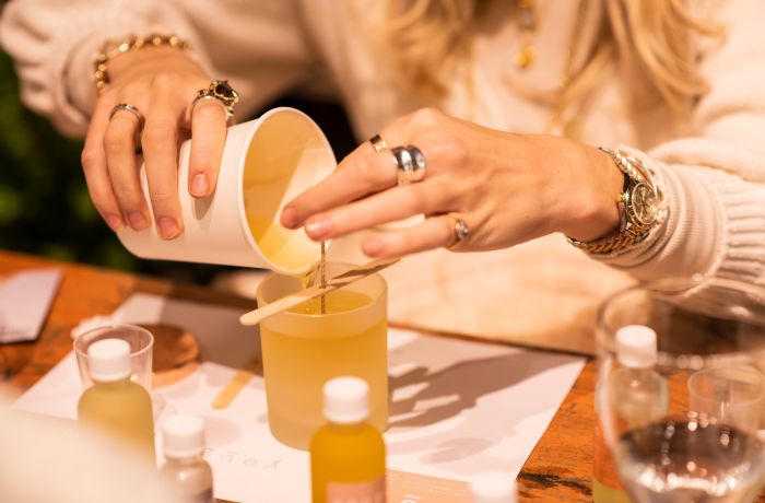 woman pouring wax into a candle jar on an aromatherapy candle workshop in london