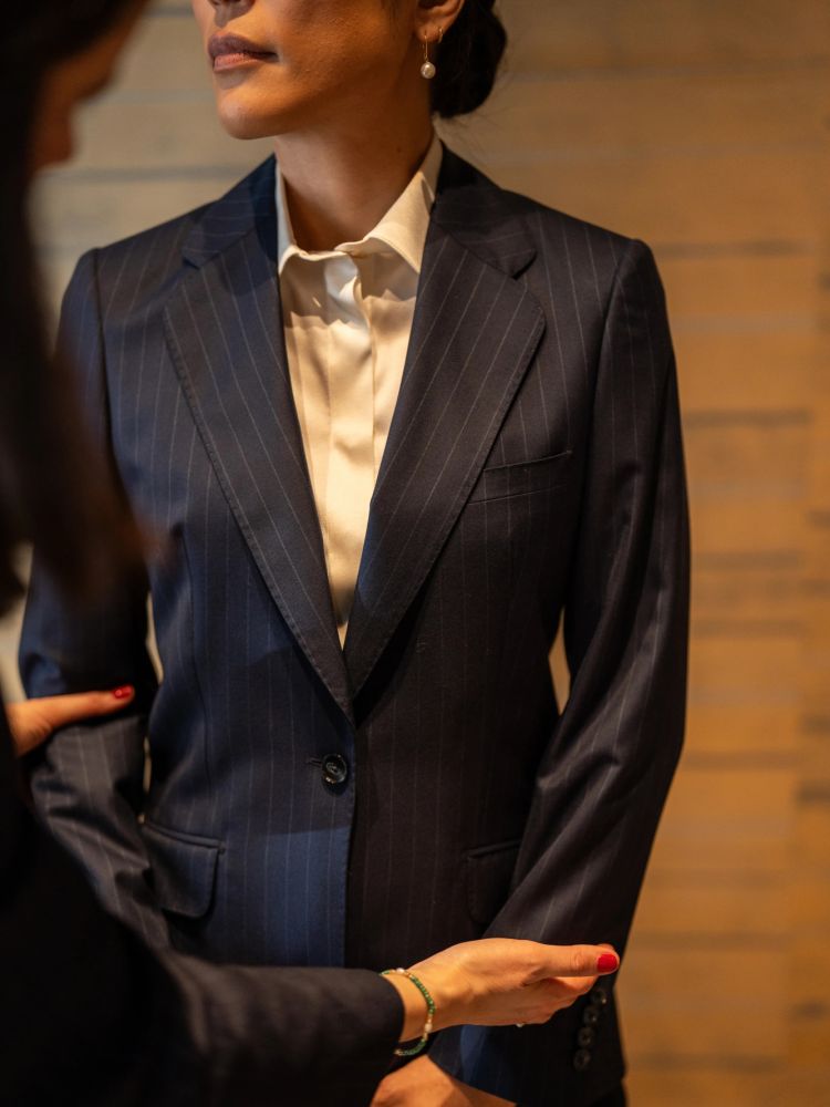 woman being fitted for a two piece suit at a design studio in savile row london