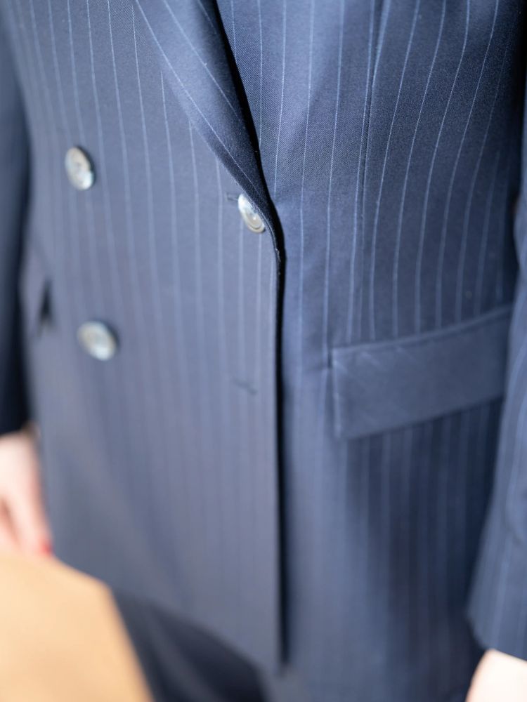 a fitting for a navy two piece suit at a design studio in savile row london