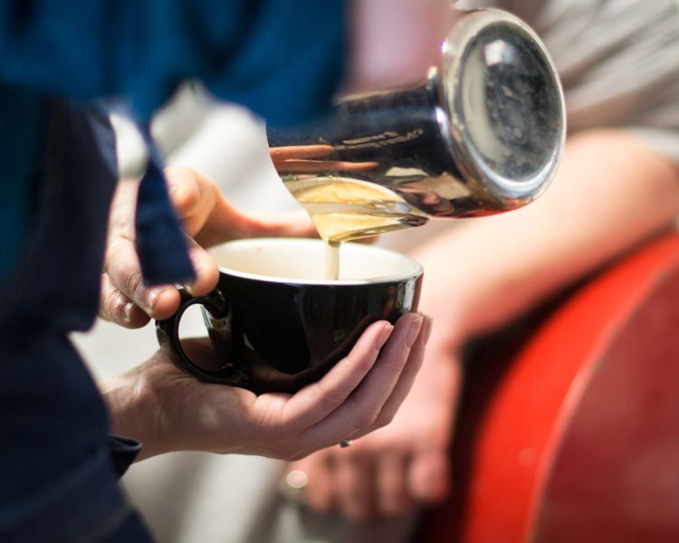 pouring milk into a coffee cup on a barista coffee workshop