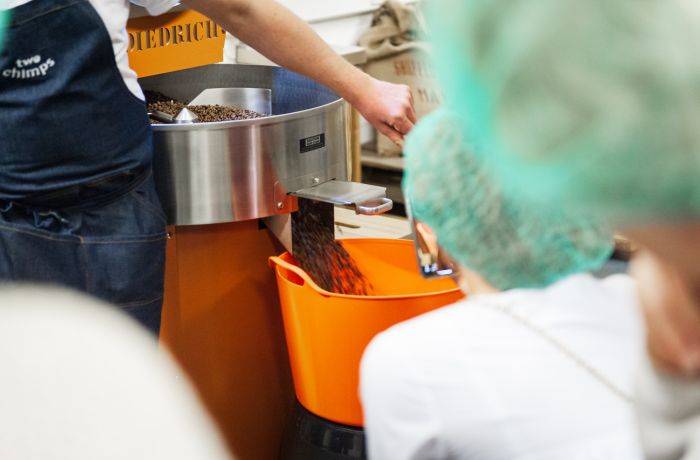 group watching coffee beans being roasted at a how to make coffee workshop