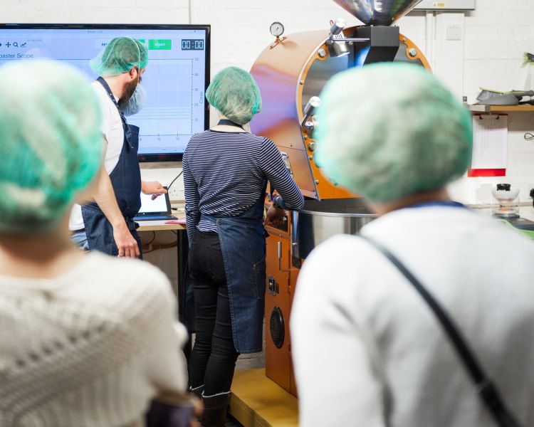 group learning the science behind how to roast and grind coffee beans