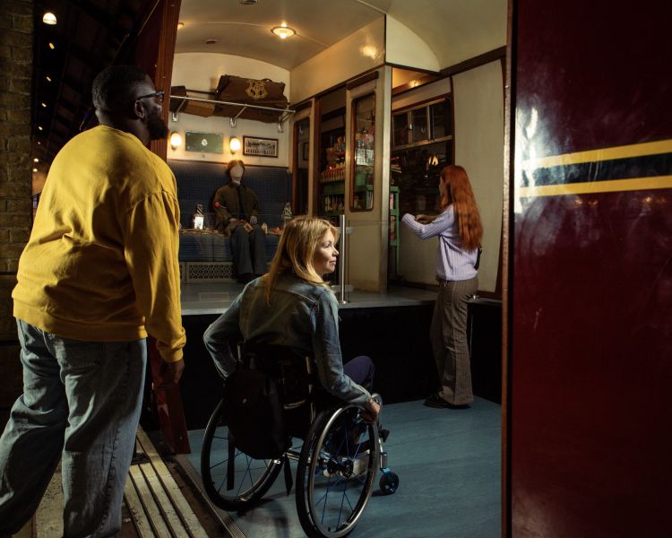 Visitors entering platform nine and three quarters at warner bros studio tour london