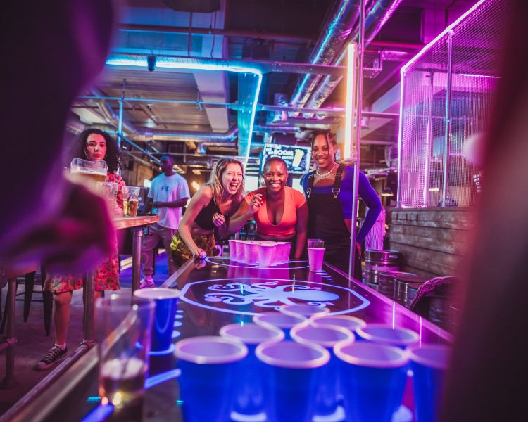 Ladies playing prosecco pong in a bar