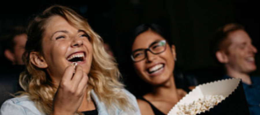 people laughing enjoying a film at the cinema with a cinema pass for up to six people