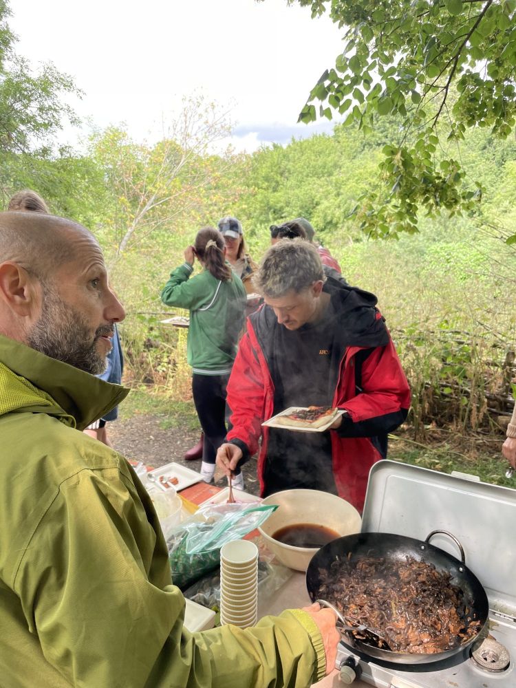 People making their pizzas using ingredients found on a foraging experience