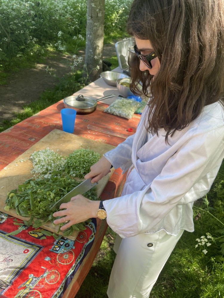 Woman chopping foraged herbs on a foraging experience