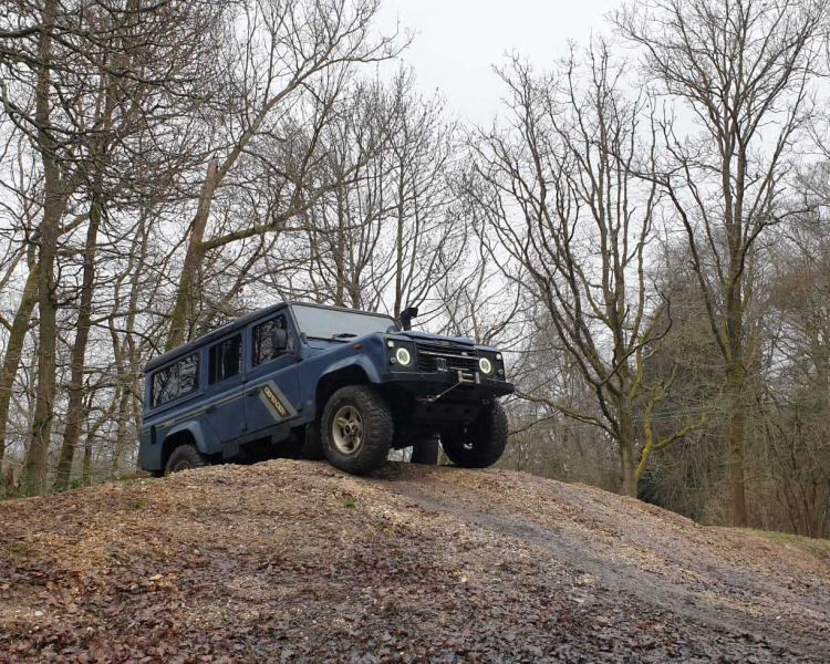 Blue land rover on an off road course in the woods