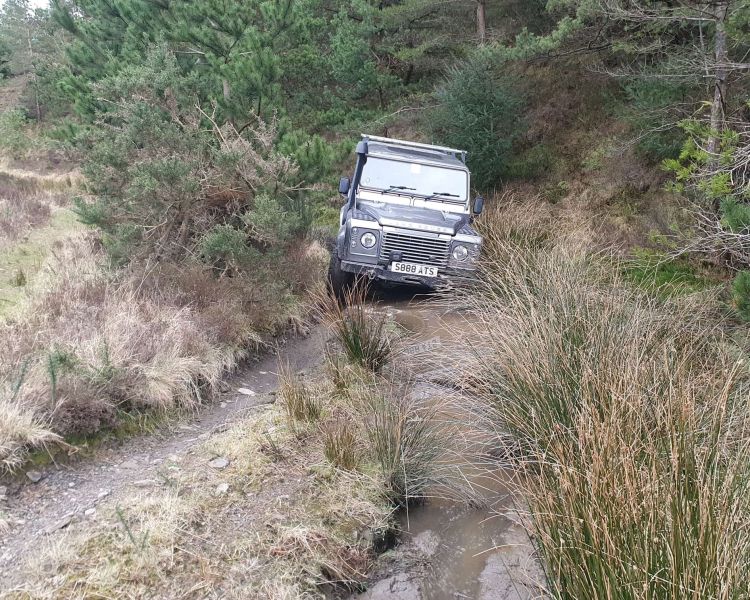 Silver land rover on an off road course