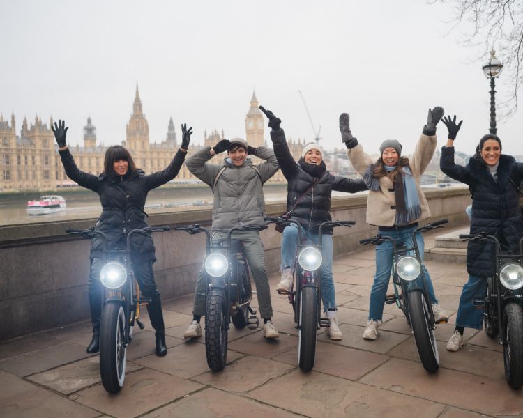 Tour group on ebikes posing for photo in front of houses of paliament
