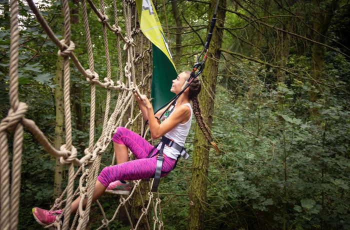 woman climbing nets on go ape treetop challenge course