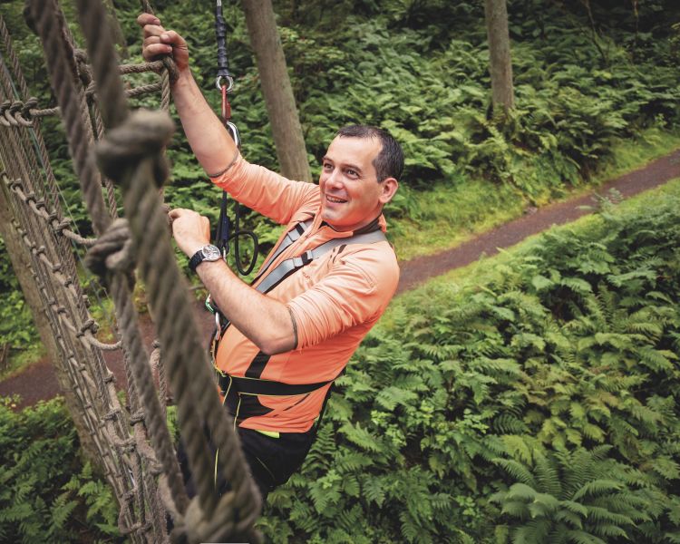 man climbing nets at treetop challenge course at go ape