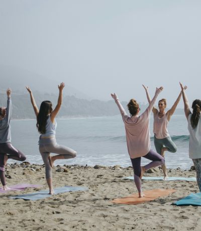 Women doing yoga on beach