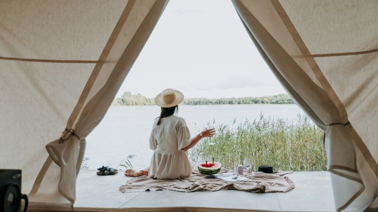 Woman looking over lake on glamping trip
