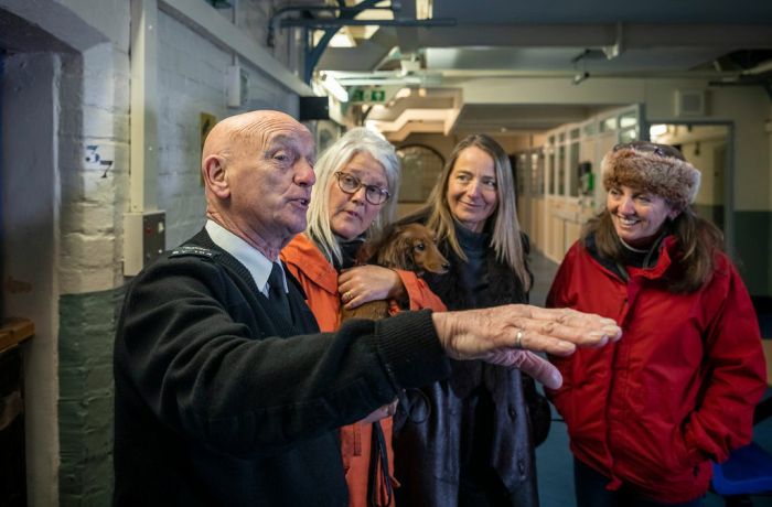 three ladies listening to a guide on a guided tour of a former prison experience day