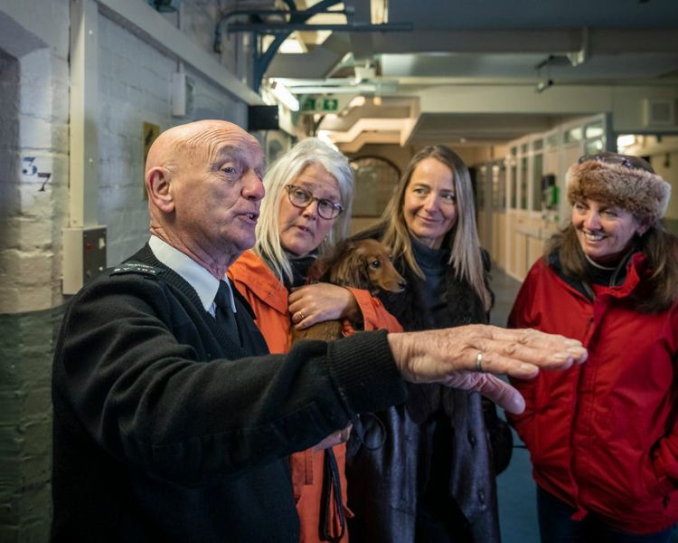 three ladies listening to a guide on a guided tour of a former prison experience day