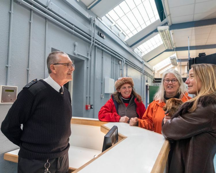 three ladies chatting to a guide on a guided tour of a former prison experience day