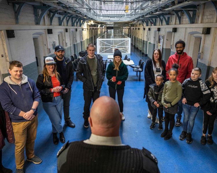 group of people listening to a guide on a guided tour of a former prison experience day
