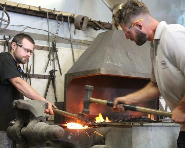 Two men forging an axe head
