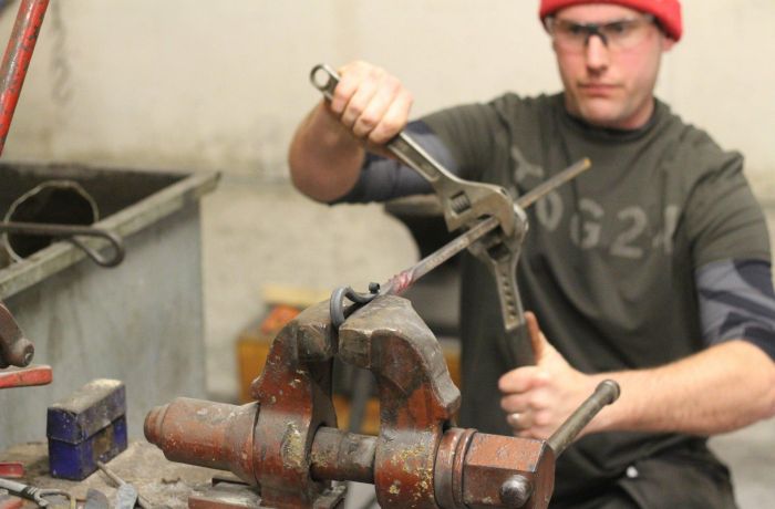 Man twisting hot metal in a vice