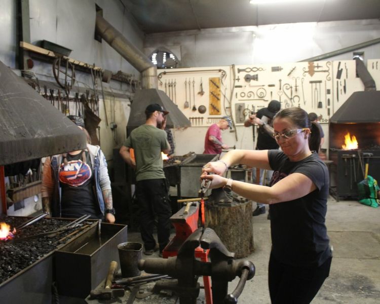 People working in a forge on a blacksmith experience day