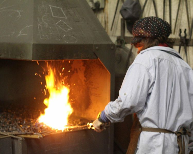 Person holding metal in a fire on a blacksmith day