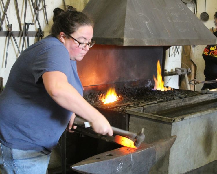 Woman hammering metal to make a knife