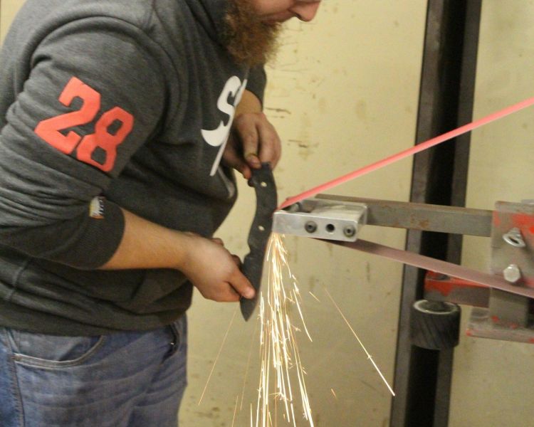 Man sharpening knife made on blacksmith experience day